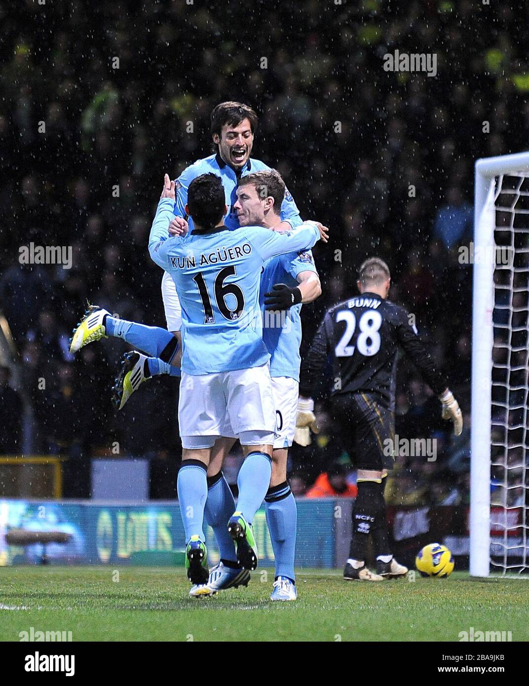 Manchester City's Edin Dzeko (right) celebrates with his team-mates Sergio Aguero (16) and David Silva (back) after scoring his team's opening goal Stock Photo