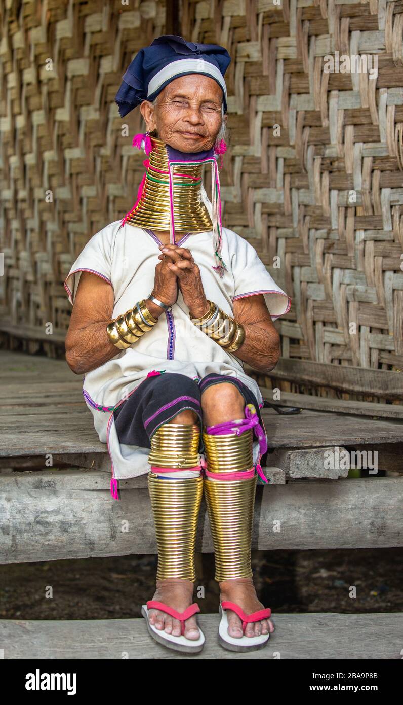 Old Padaung woman in traditional dress and with metal rings around her  neck, arms and legs is sitting on a staircase in a village house Stock  Photo - Alamy