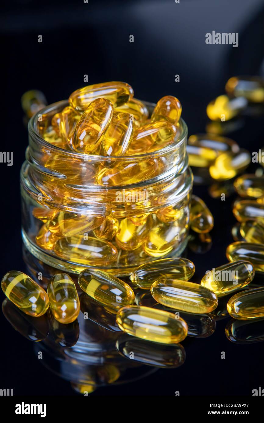 Omega fish oil softgels dietary supplement in jar. Healthy life and heart health concept. Stock Photo