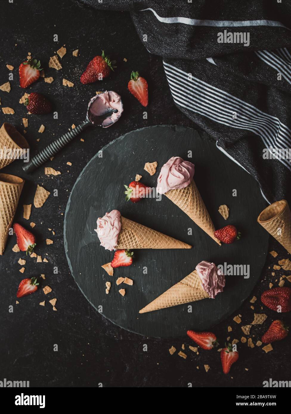 Top view of strawberry ice cream cones on a black background. Stock Photo