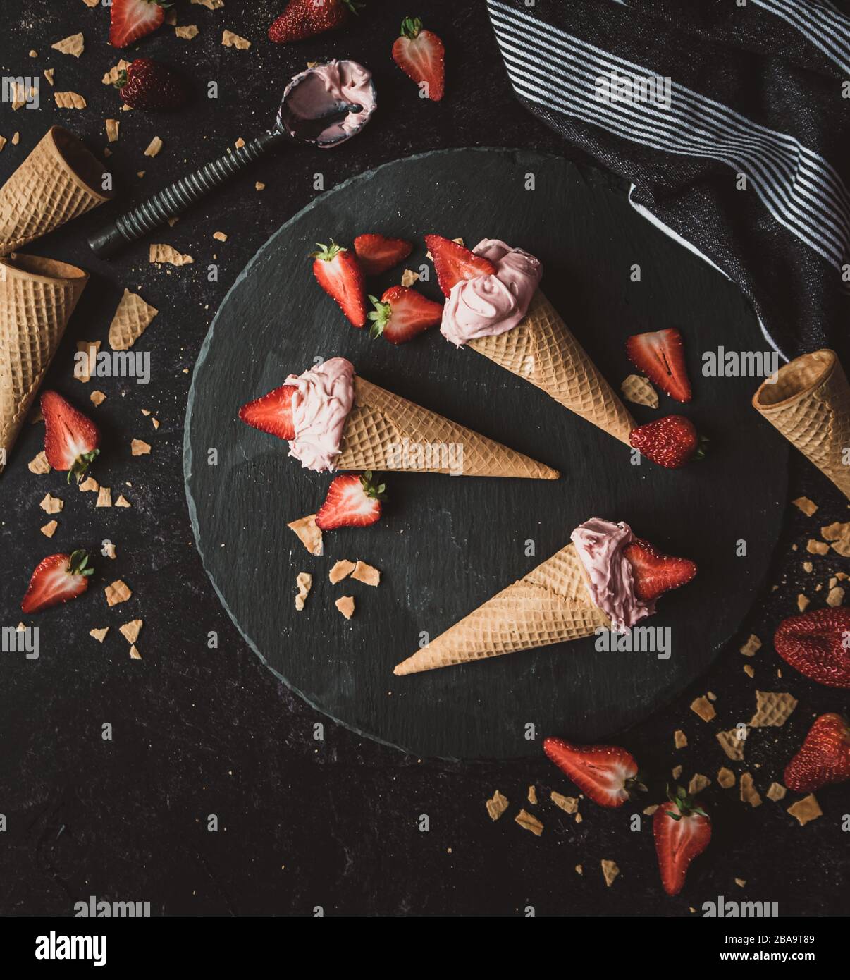Top view of strawberry ice cream cones on a black background. Stock Photo