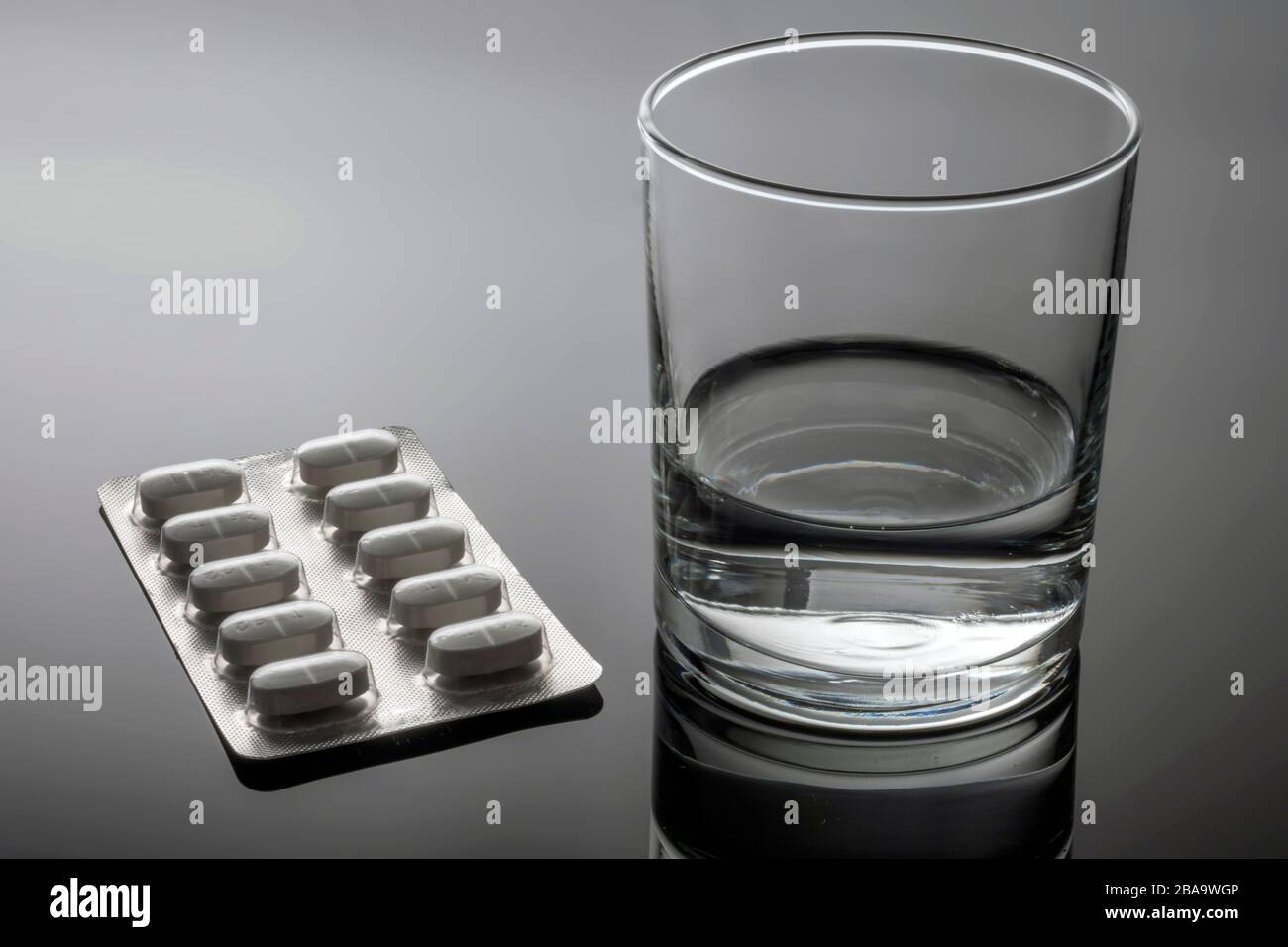 Pills Blister along with a water glass, conceptual image Stock Photo