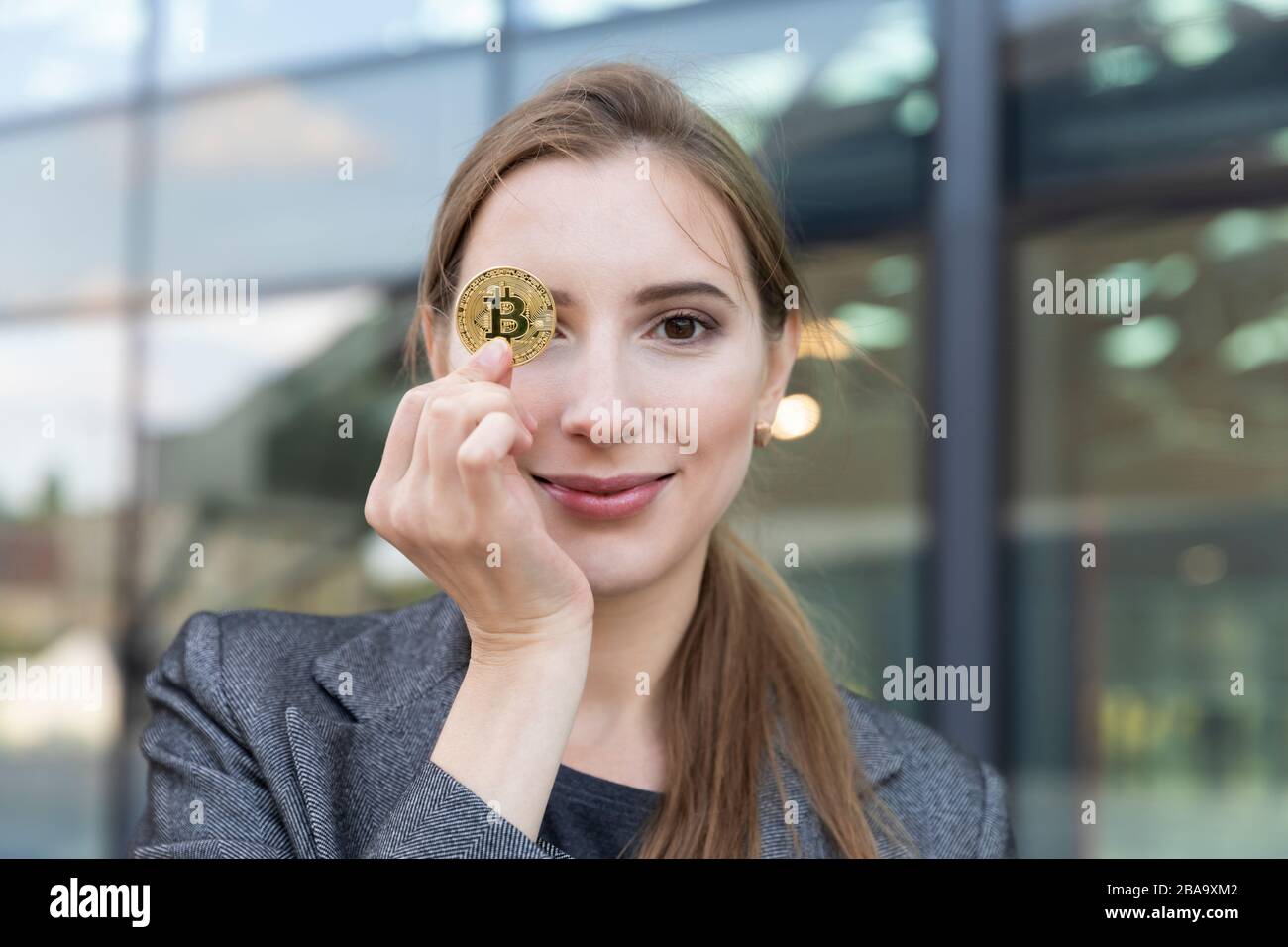 The young beautiful woman holds bitcoin in a hand. She is a business lady  and invested her money in cryptocurrency, planning to make good money on it  Stock Photo - Alamy
