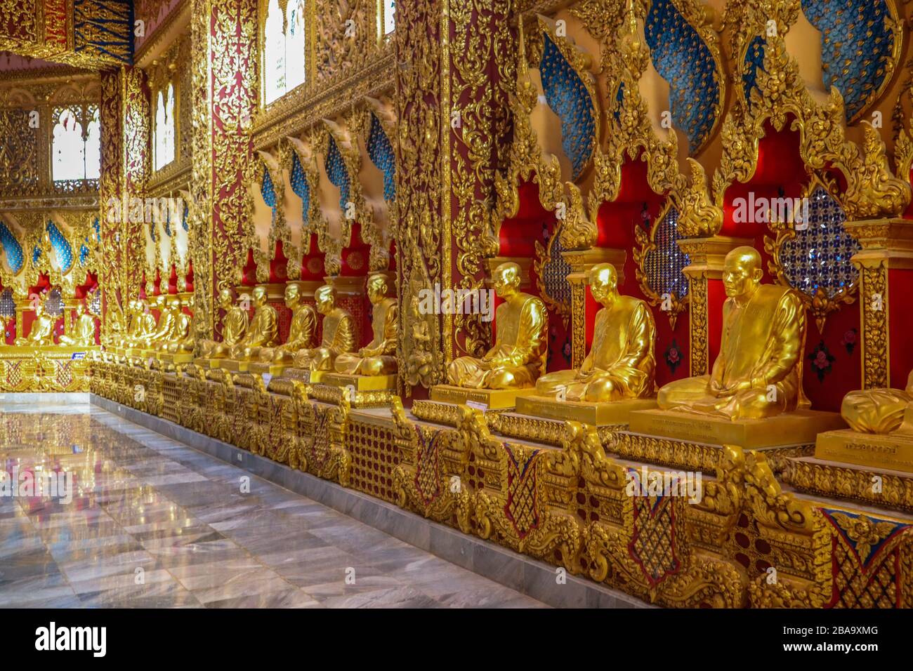 Golden Statues of monks in a Buddhist temple Stock Photo