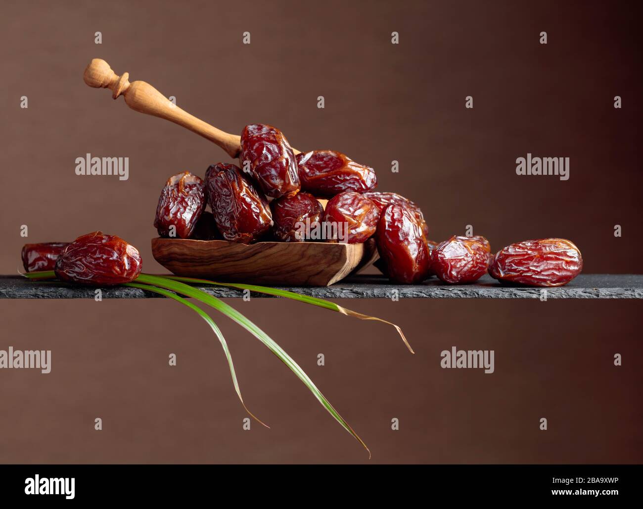 Closeup sweet dried dates in wooden dish. Copy space Stock Photo - Alamy