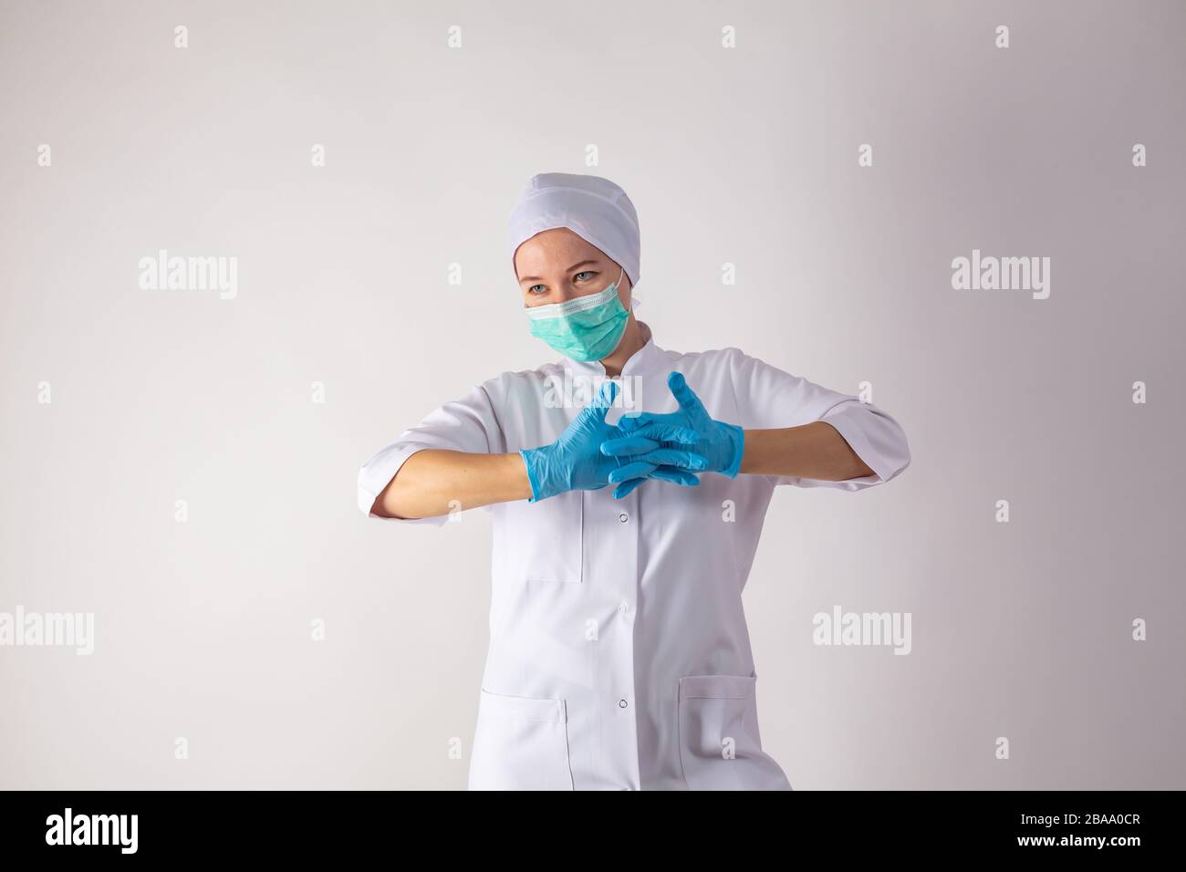 Cute girl on a monophonic background shows latex gloves. Stock Photo