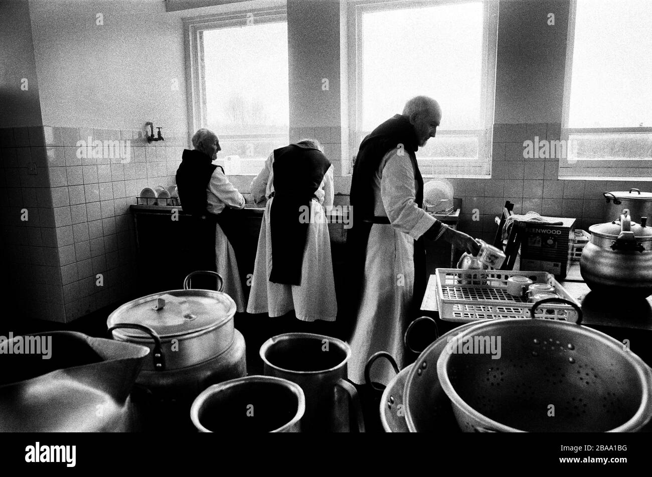 Monks working in the kitchen at Sancta Maria Abbey at Nunraw, East Lothian, home since 1946 to the Order of Cistercians of the Strict Observance. Around 15 monks were resident at Nunraw in 1996, undertaking a mixture of daily tasks and strict religious observance. The present purpose-built building dates from 1969 when the monks moved from the nearby Nunraw house. Stock Photo