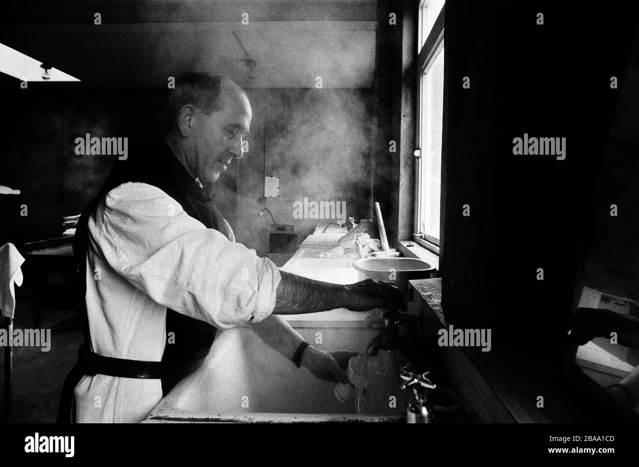 A monk working in the kitchen at Sancta Maria Abbey at Nunraw, East Lothian, home since 1946 to the Order of Cistercians of the Strict Observance. Around 15 monks were resident at Nunraw in 1996, undertaking a mixture of daily tasks and strict religious observance. The present purpose-built building dates from 1969 when the monks moved from the nearby Nunraw house. Stock Photo