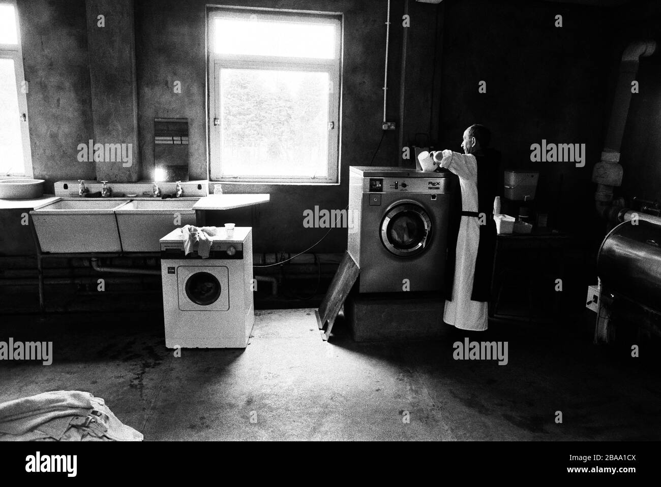 A monk working in the laundry at Sancta Maria Abbey at Nunraw, East Lothian, home since 1946 to the Order of Cistercians of the Strict Observance. Around 15 monks were resident at Nunraw in 1996, undertaking a mixture of daily tasks and strict religious observance. The present purpose-built building dates from 1969 when the monks moved from the nearby Nunraw house. Stock Photo