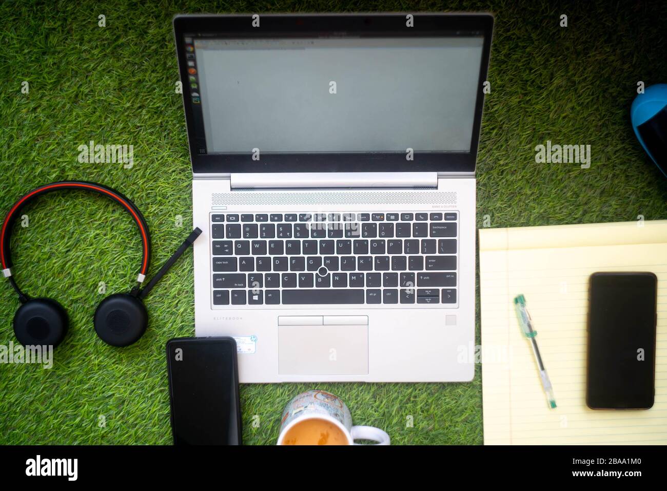 Top down shot of a laptop with headphone mobile phone notepad