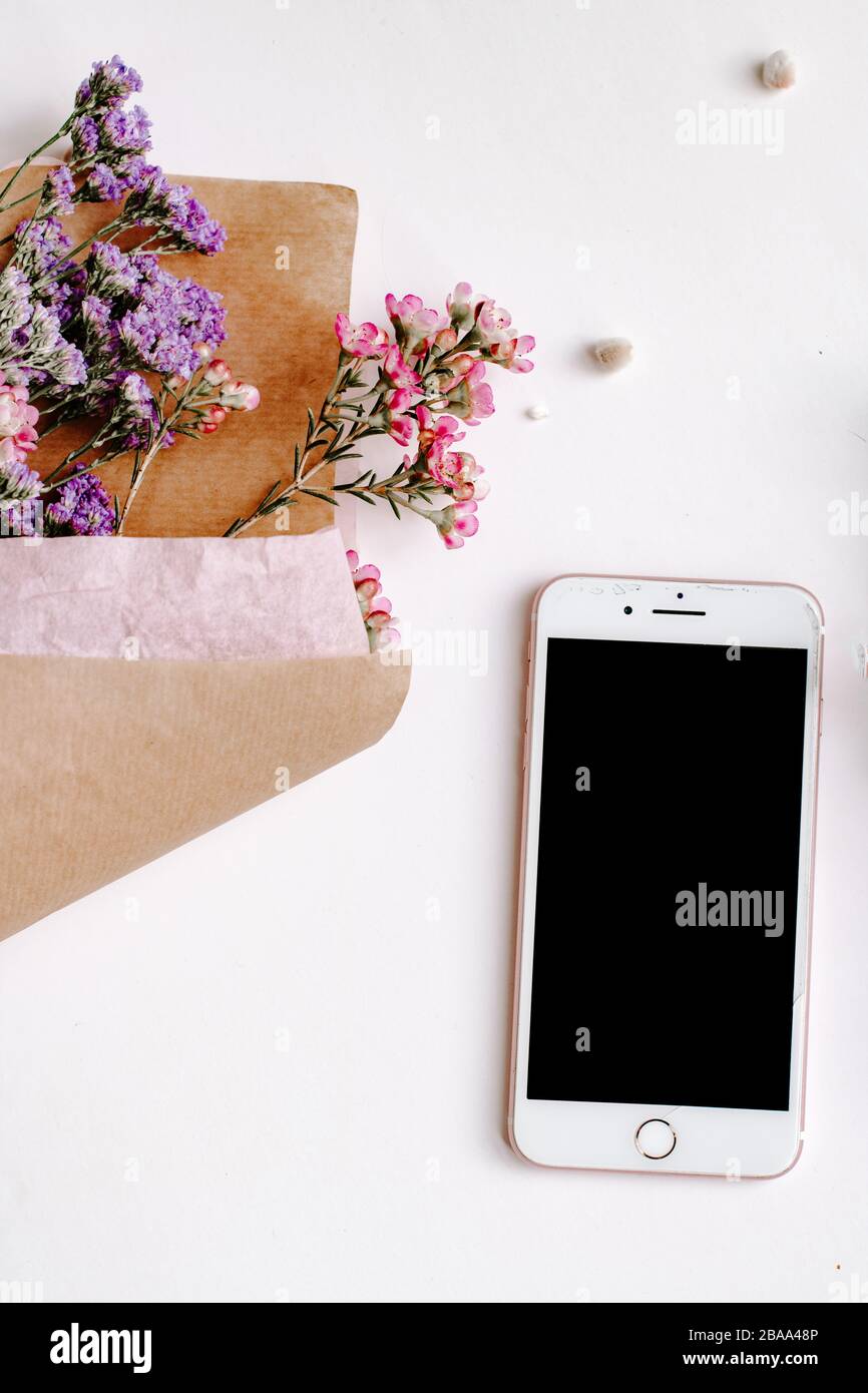 Iphone, phone mockup up, white background flatlay, bunch of flowers, mobile phone, feminine concept, girly, delicate, technology, blog stock photo Stock Photo