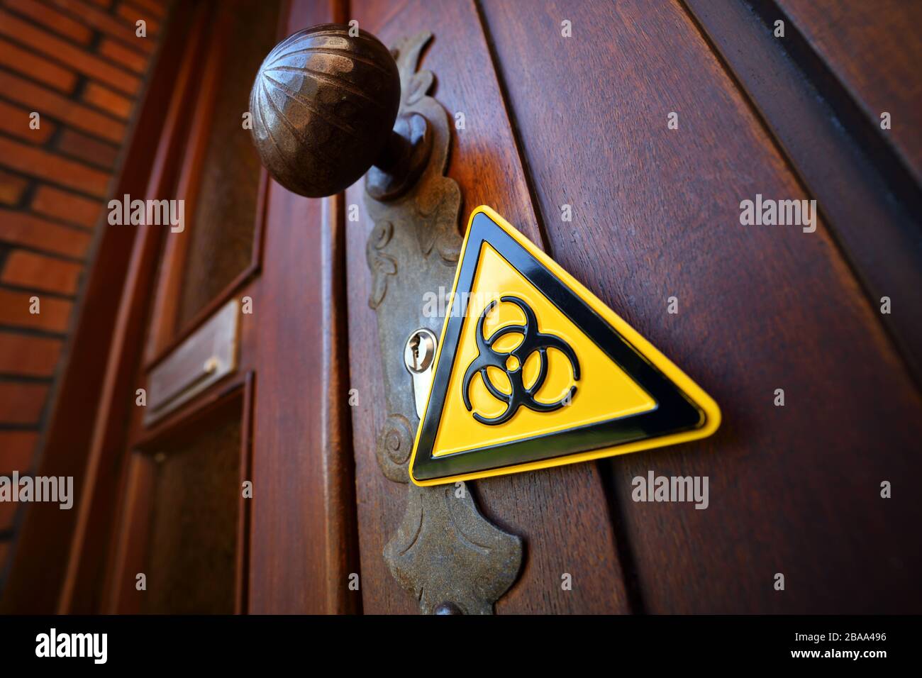 Biology danger sign in a front door, symbolic photo for domestic quarantine, Biogefährdungsschild an einer Haustür, Symbolfoto für häusliche Quarantän Stock Photo