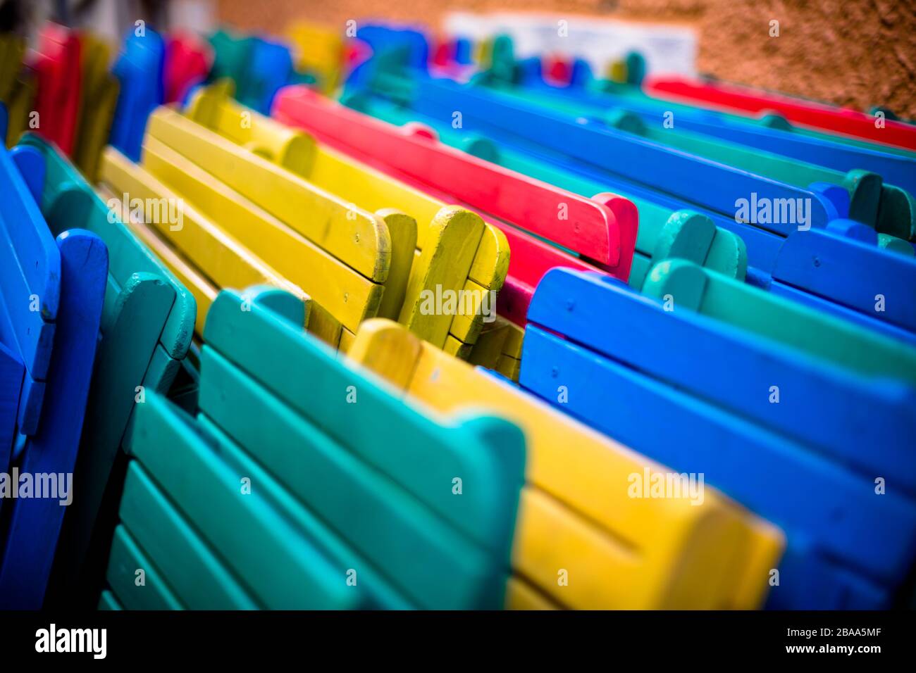 A concept shot of a bunch of stacked wooden beach chairs. Stock Photo