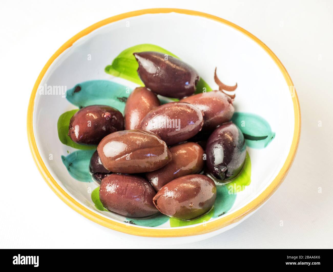 Kalamata olives in a bowl on a white tablecloth Stock Photo