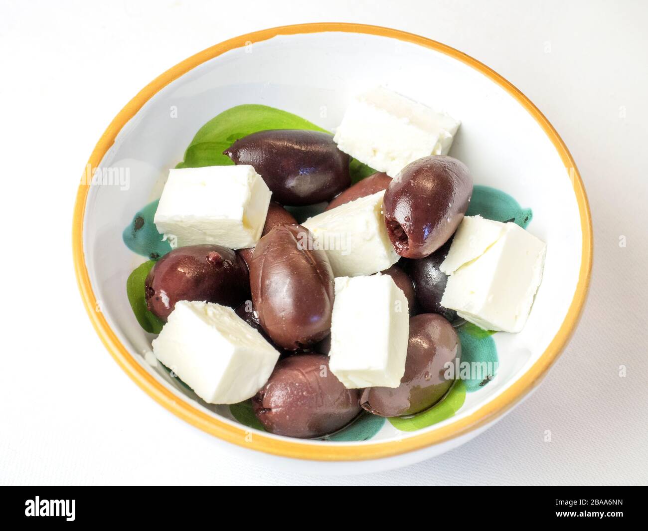 Kalamata olives and feta cheese in a bowl on a white tablecloth Stock Photo