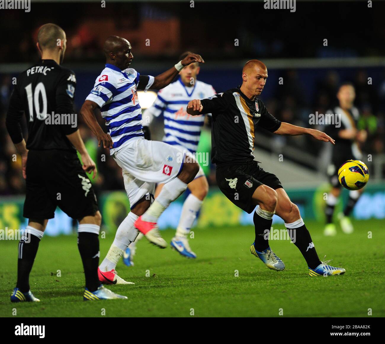 Queens Park Rangers' Stephane Mbia and Fulham's Steve Sidwell battle for the ball Stock Photo