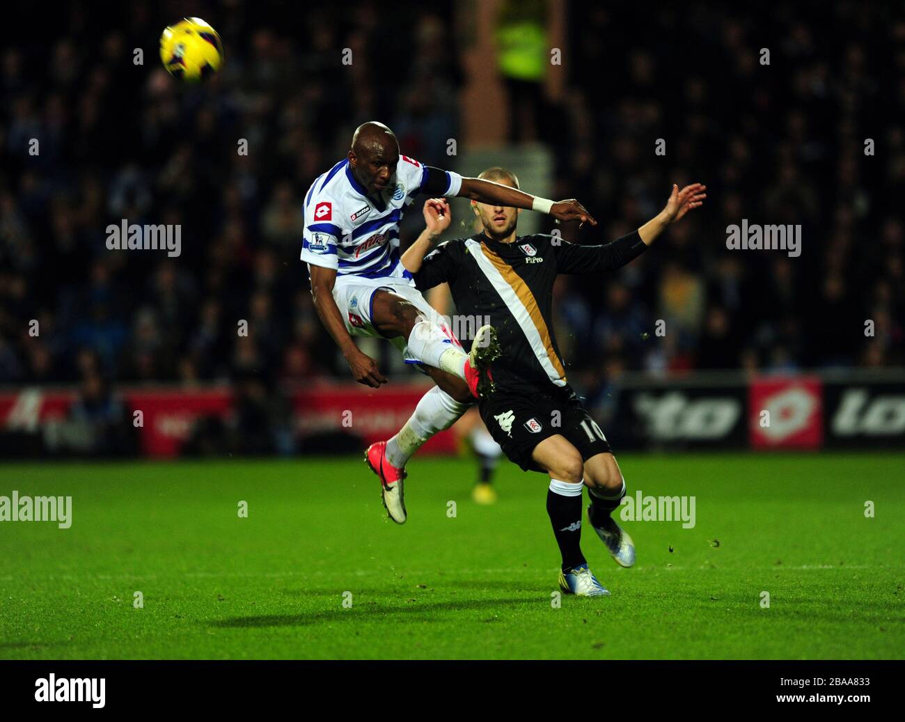 Queens Park Rangers' Stephane Mbia (left) and Fulham's Steve Sidwell battle for the ball Stock Photo