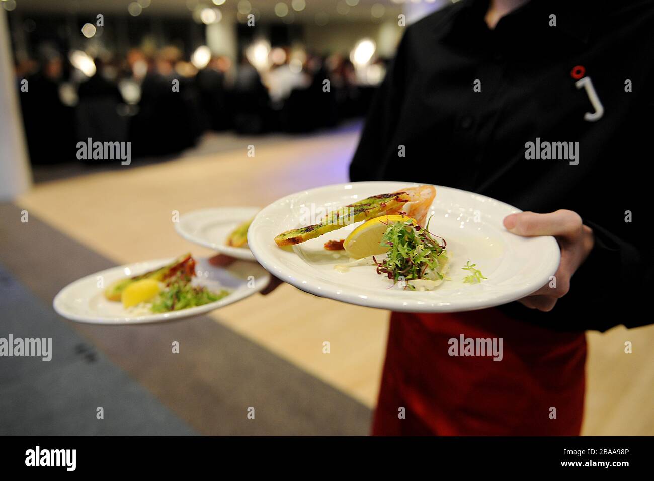 Waiting staff deliver food to guest's tables Stock Photo