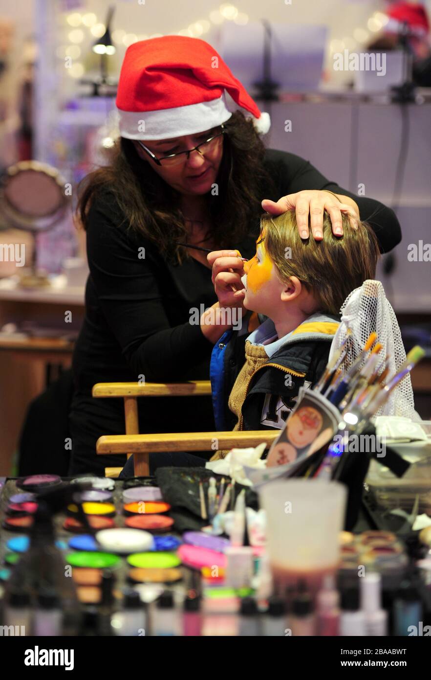 A young punter has her face painted in one of the Hi Life Christmas Show market stalls at Sandown Park. Stock Photo
