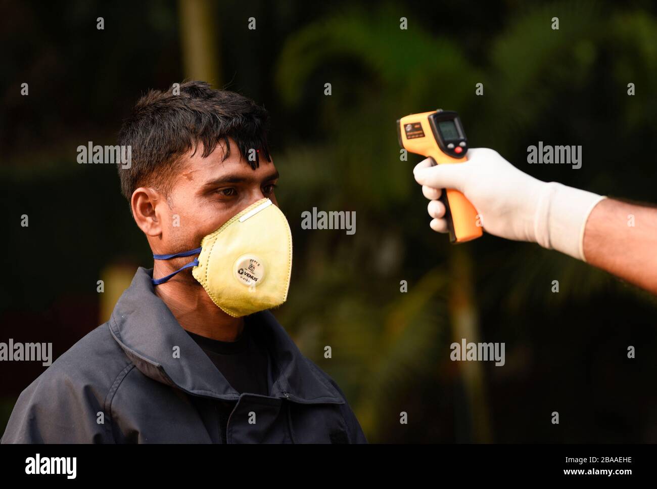 Guwahati, Assam, India. 26th Mar, 2020. Police personnel thermal screening a person before entering to Governor House to spray disinfectant, in Guwahati. Credit: David Talukdar/ZUMA Wire/Alamy Live News Stock Photo