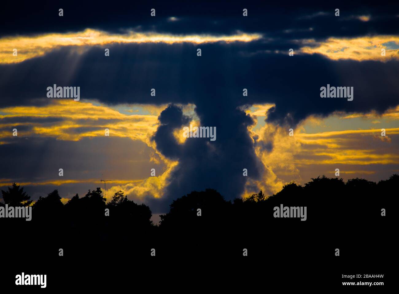 Beautifully shaped clouds settle in the sky as the sun sets on a hot afternoon in Ireland. Stock Photo