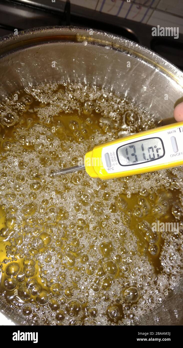 Vertical closeup of a cooking thermometer in a boiling oil under the lights  Stock Photo - Alamy