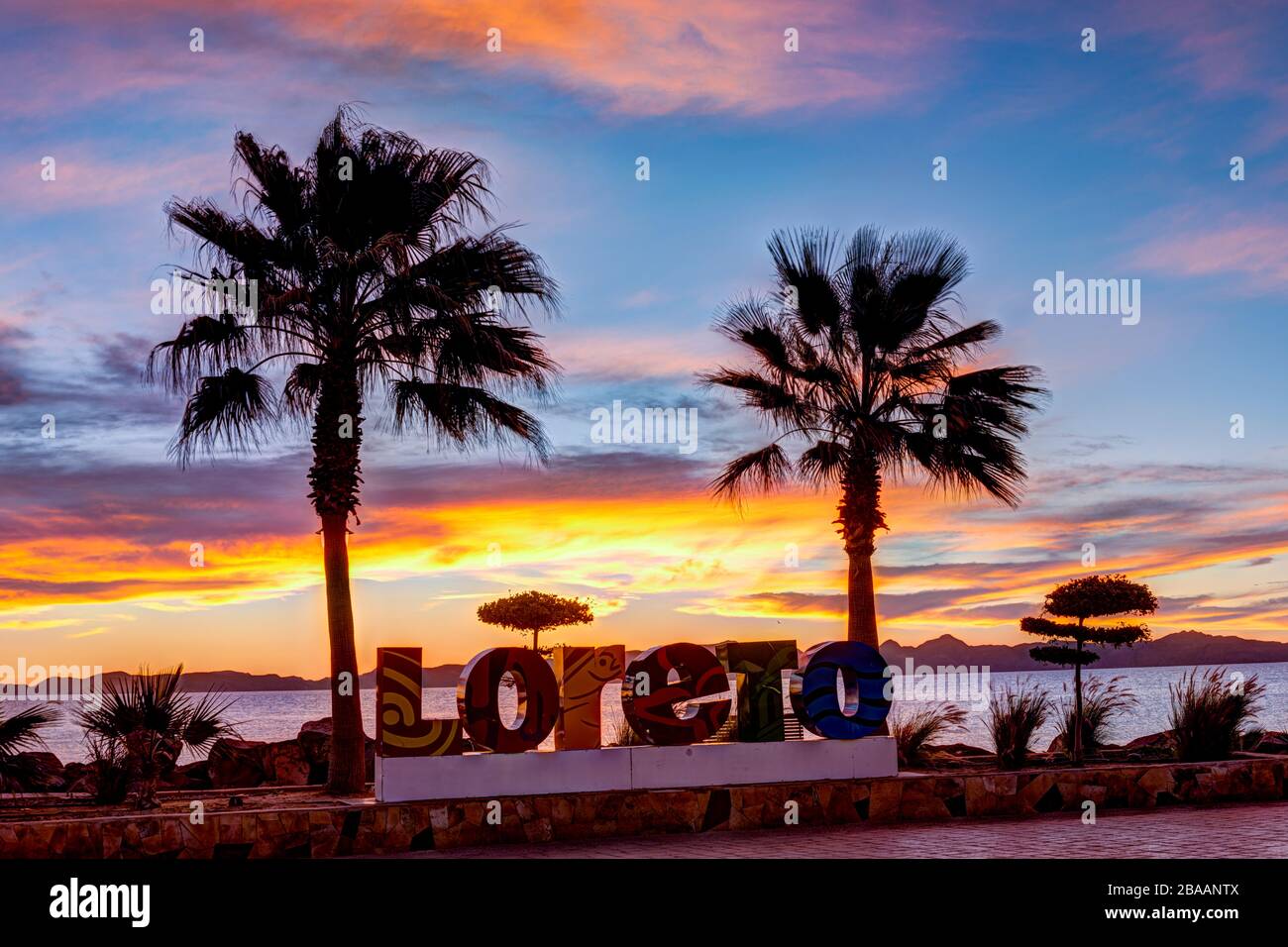 Sunrise behind Loreto sign with palm trees, Malecon, Loreto, Baja 