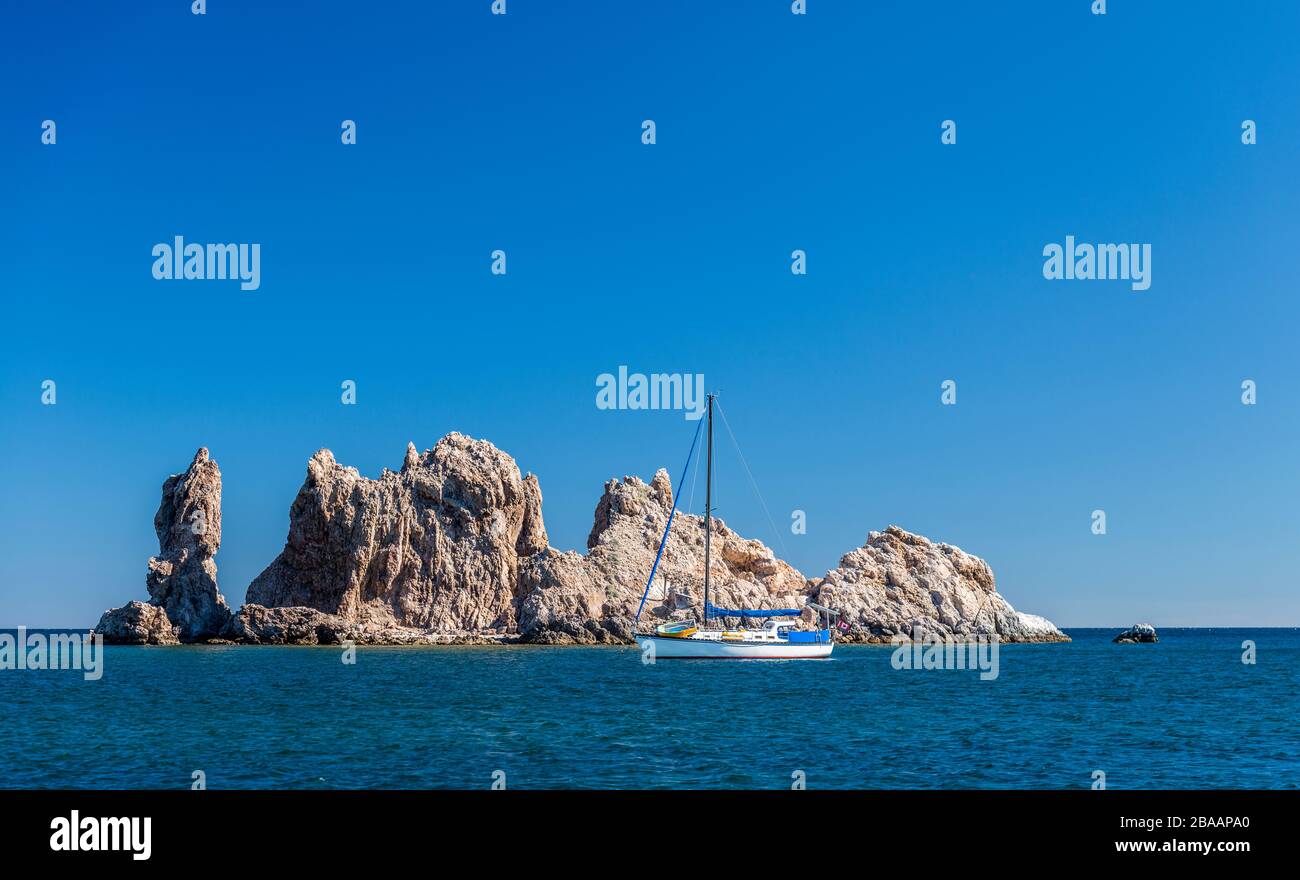 Sailboat anchored in sea near rock formation, Baja California Sur, Mexico Stock Photo