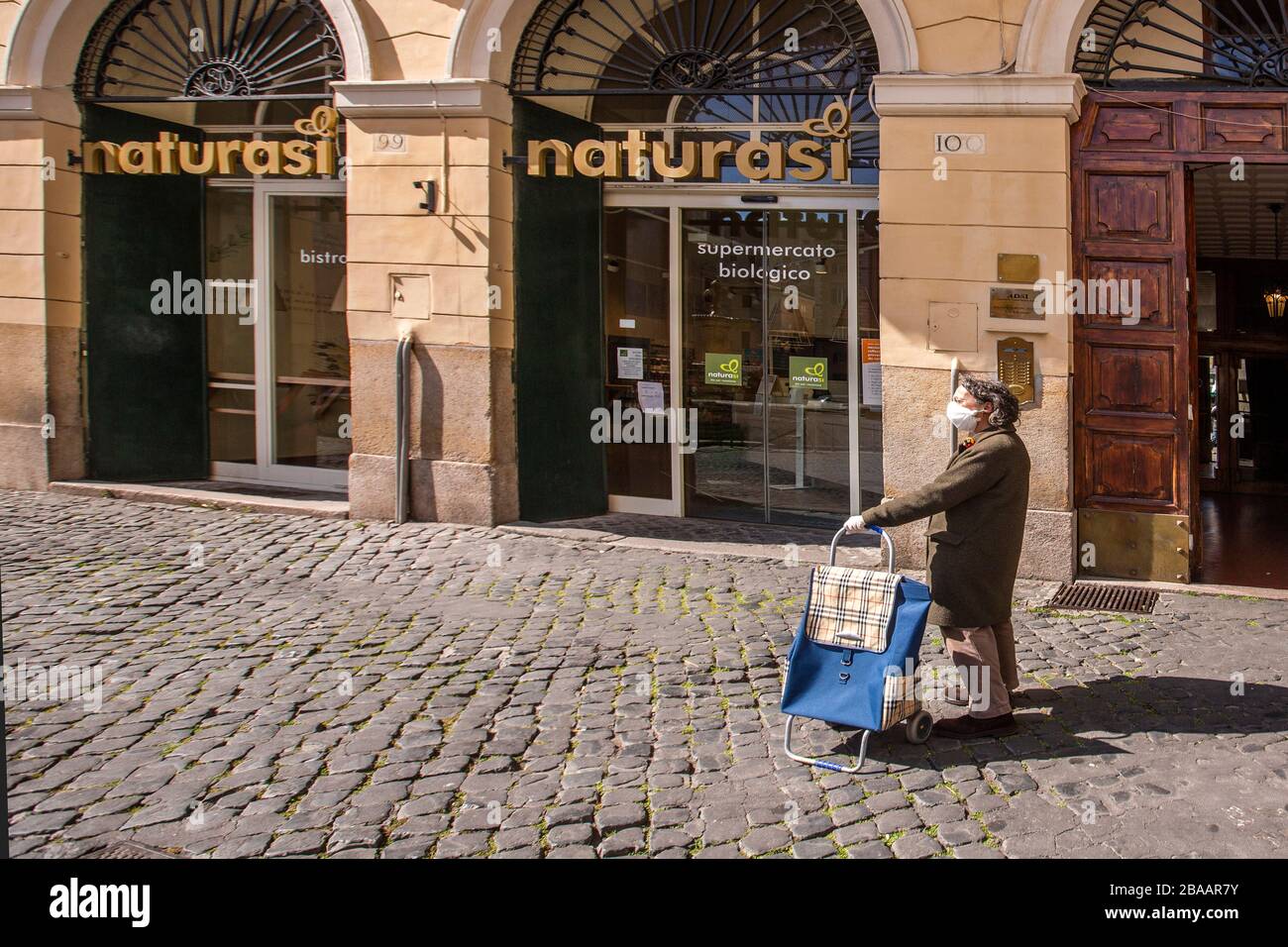 Rome March 25th 2020 Rome during the Coronavirus pandemic. people wearing mask in line at the shop in Piazza Farnese  Photo by Elio Castoria Stock Photo