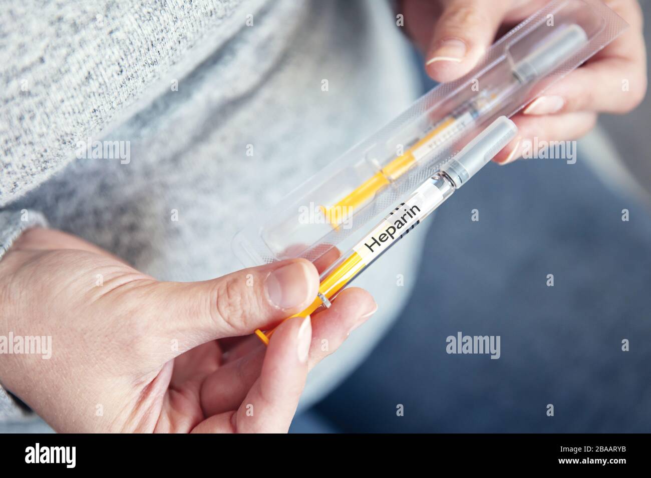 Woman's hands hold disposable syringe with heparin Stock Photo