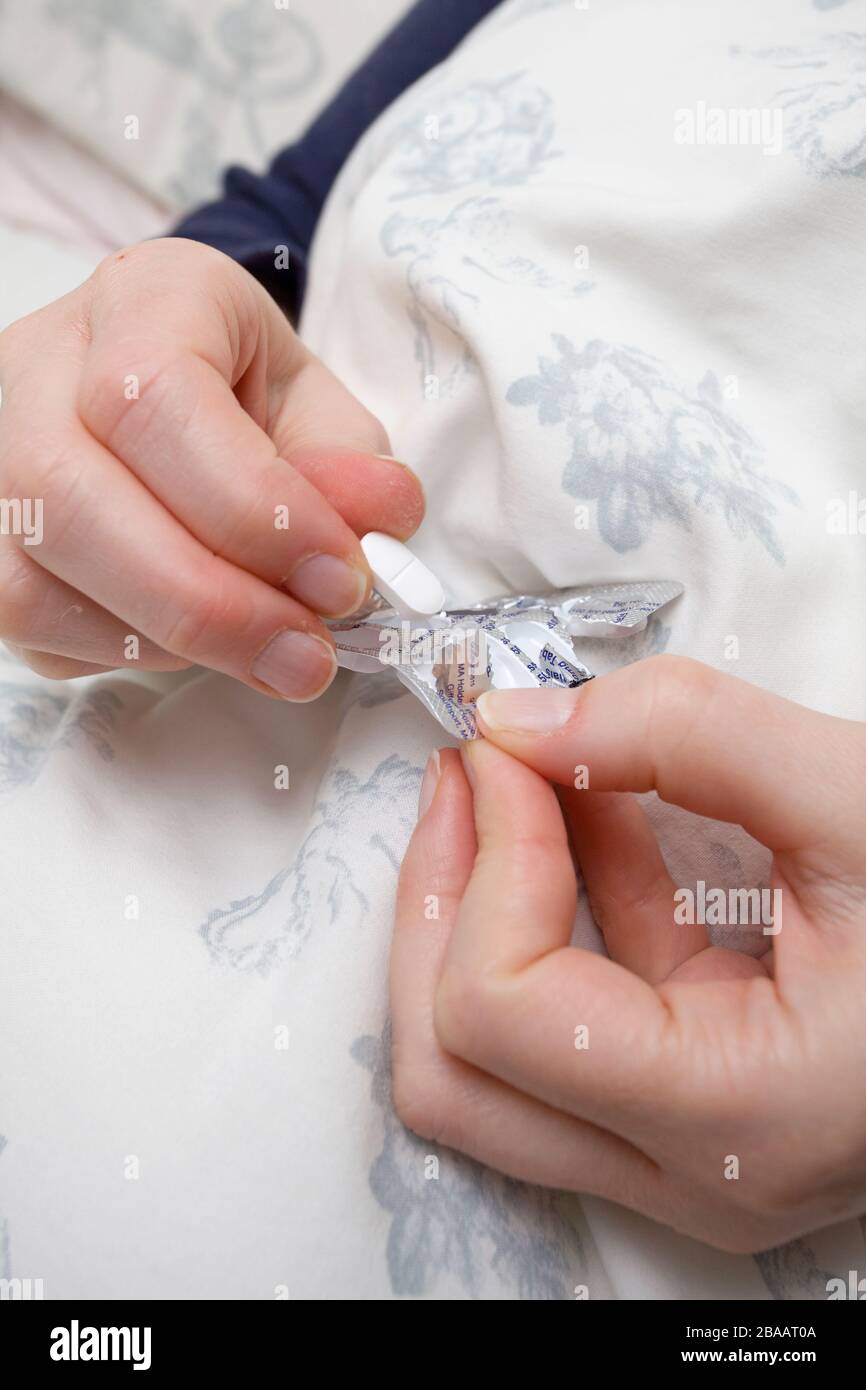 woman taking a painkiller tablet from packet Stock Photo