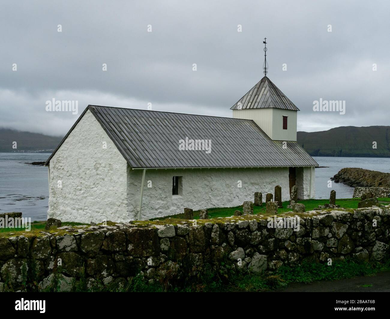 Faroe Islands. This charming white ST. OLAV’S church dates back to the 12th century and is still in use today, making it the oldest one in the Faroe I Stock Photo
