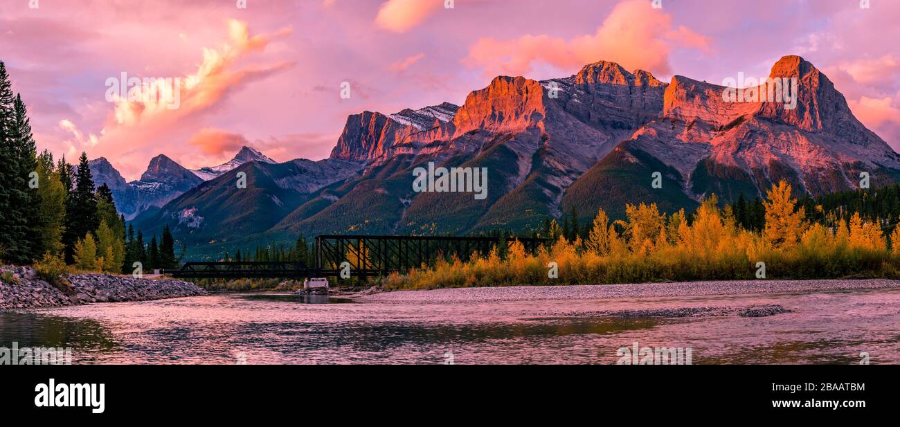 View of rail bridge over river and Three Sisters Mountain Canmore, Alberta, Canada Stock Photo