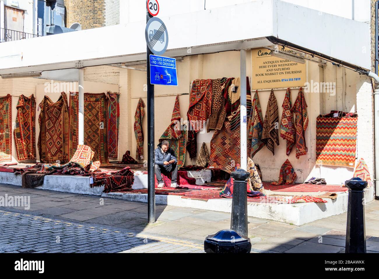 A carpet seller in Camden Passage in Islington, unusually quiet as people stay at home at the onset of the coronavirus pandemic, London, UK Stock Photo