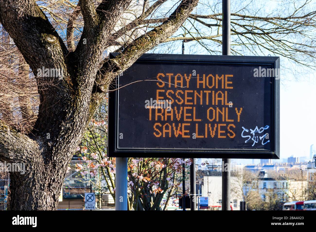 An illuminated dot matrix traffic sign reading 'stay home, essential travel only saves lives' during the coronavirus pandemic, London, UK Stock Photo