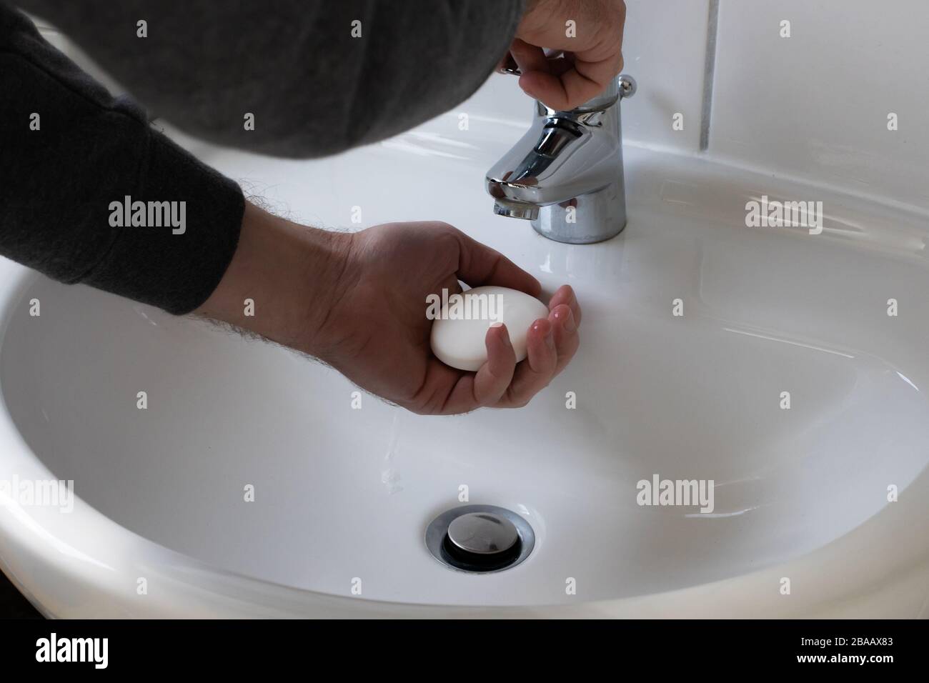 Detail of a Young male washing his Hands with Soap under running water in order to reduce infection Risk during corona Virus pandemic Stock Photo