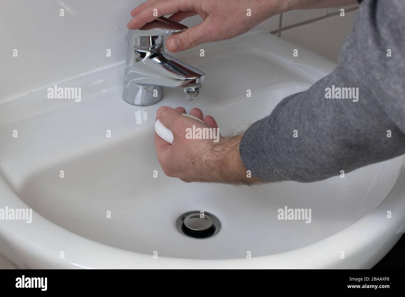 Detail of a Young male washing his Hands with Soap under running water in order to reduce infection Risk during corona Virus pandemic Stock Photo