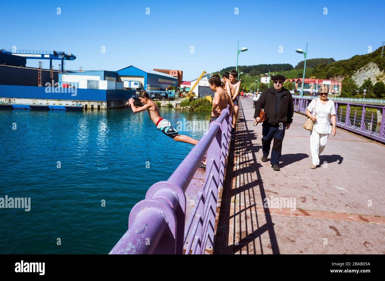 Zumaia, Gipuzkoa, Basque Country, Spain - July 15th, 2019 : Teenagers jump to the water from a bridge over ria del Urola estuary. Stock Photo