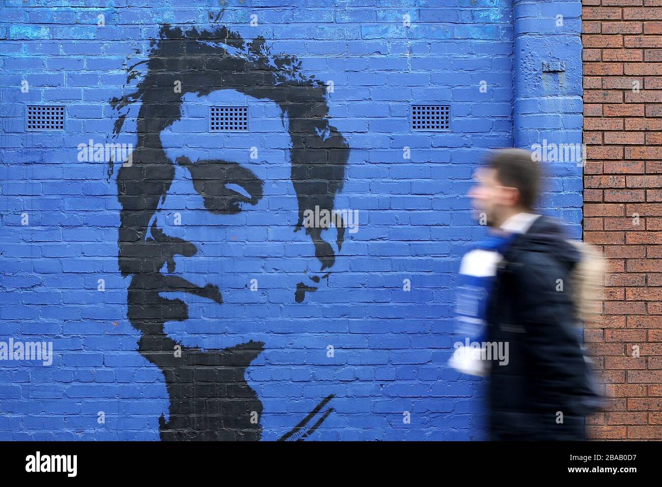 An exterior general view of a fan walking past a mural of ex Everton Defender Phil Jageilka Goodison Park Stock Photo