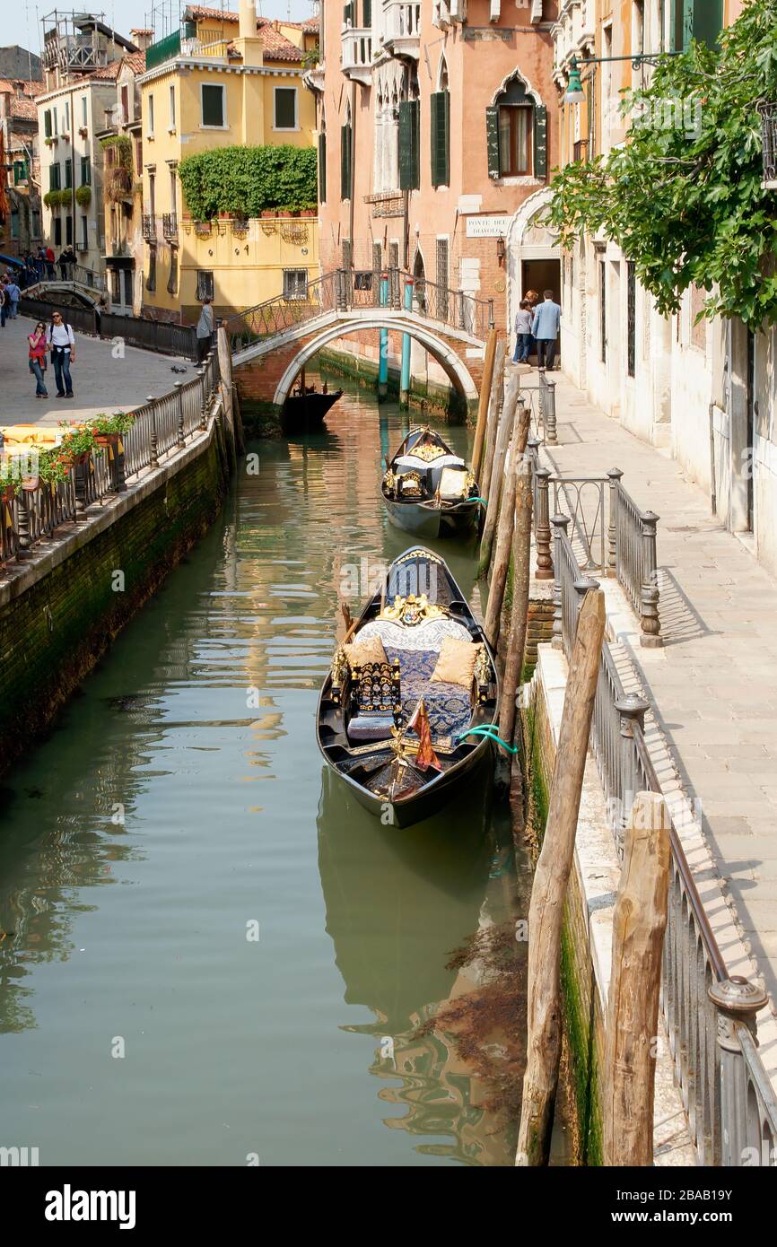 Two gondolas tied to the side of the canal. Venice, Italy Stock Photo