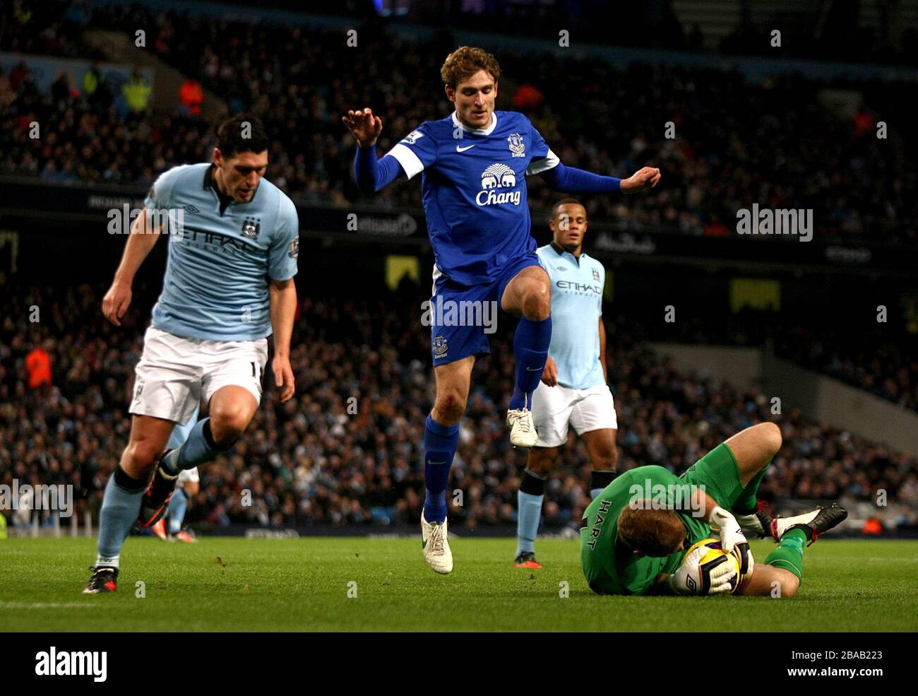 Manchester City goalkeeper (right) makes a save at the feet of Everton's Nikica Jelavic Stock Photo