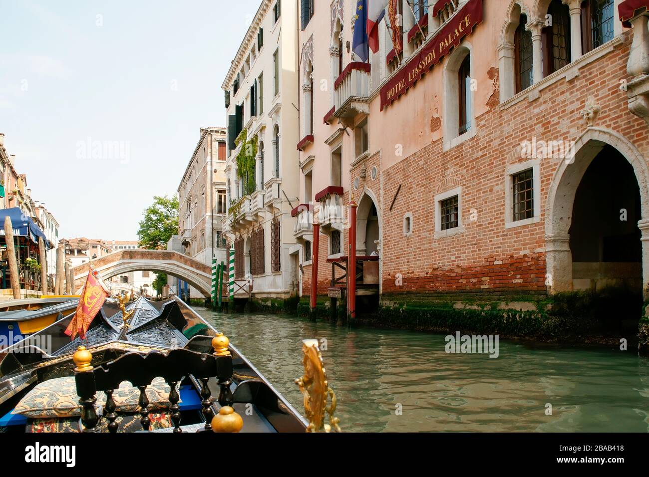 View while riding in a gondola. Approaching an arched bridge with buildings on both sides of the gondola. Venice, Italy. Stock Photo