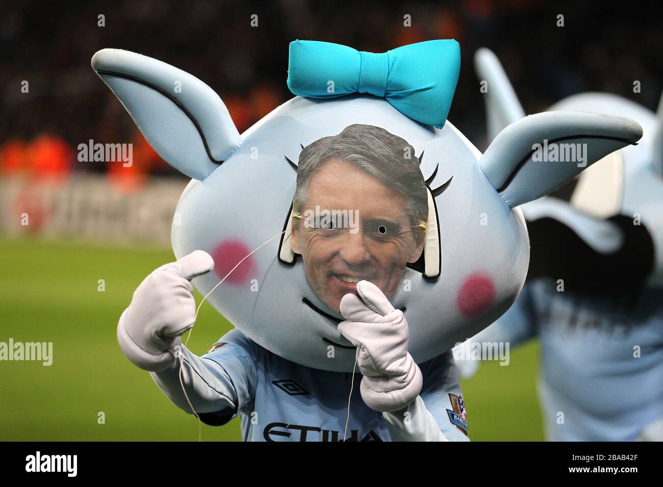 Manchester City's mascot Moonbeam wears a face mask of manager Roberto Mancini Stock Photo