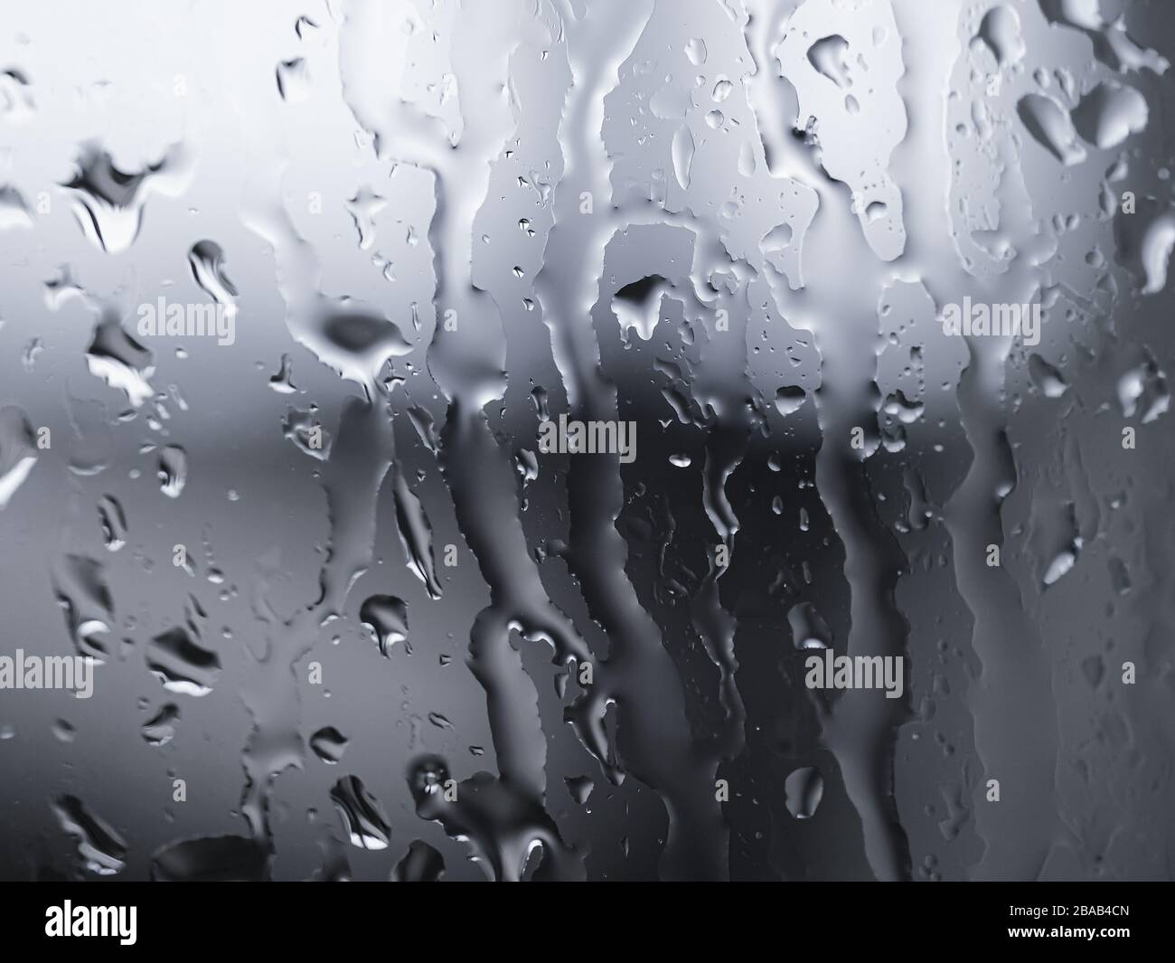 Rain water drops on glass over blur silver background,abstract texture pattern Stock Photo