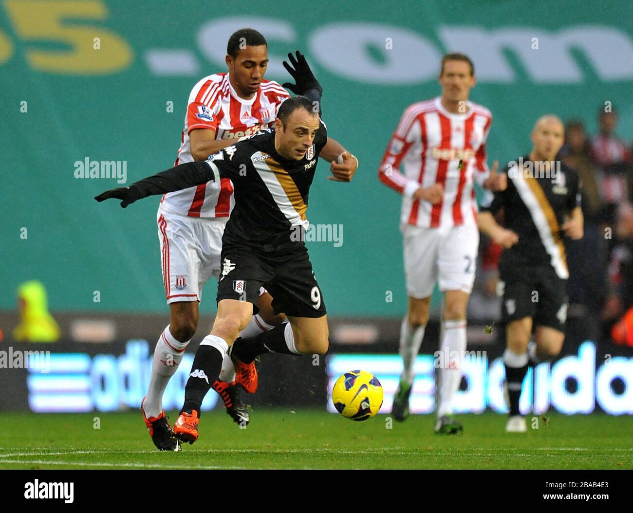 Fulham's Dimitar Berbatov (centre) and Stoke City's Steven Nzonzi battle for the ball Stock Photo