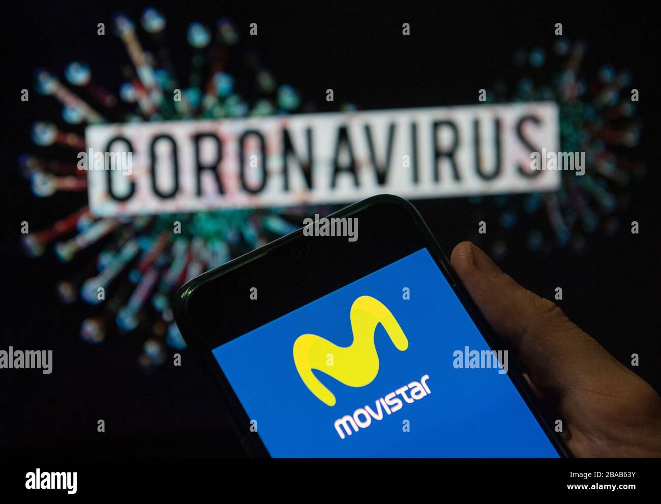 In this photo illustration the Spanish telecommunications brand owned by Telefonica and largest mobile phone operator, Movistar, logo seen displayed on a smartphone with a computer model of the COVID-19 coronavirus on the background. Stock Photo