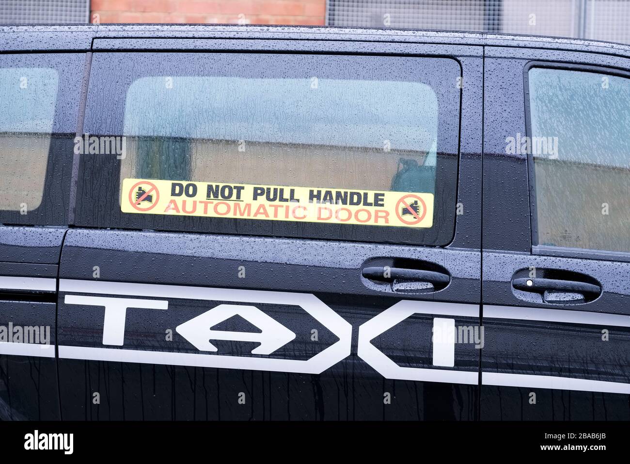 Taxi automatic door do not pull handle sign on black cab car Stock