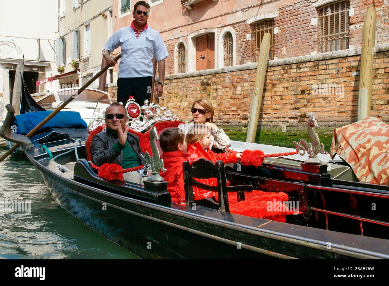 A happy family riding in a gondola. Venice, Italy. NMR Stock Photo