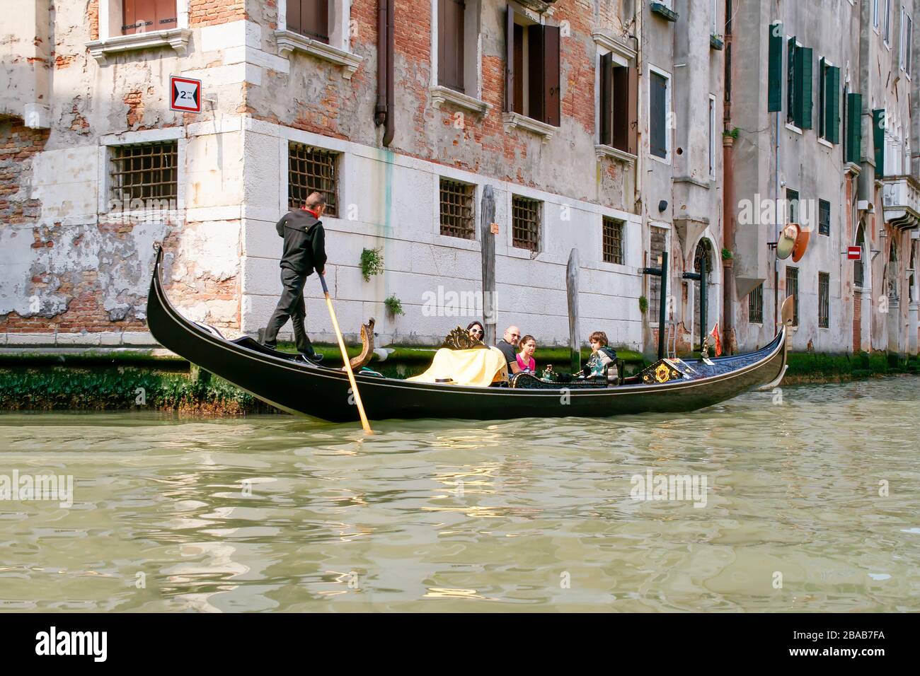 A happy family shown riding in a gondola. Venice Italy. NMR Stock Photo