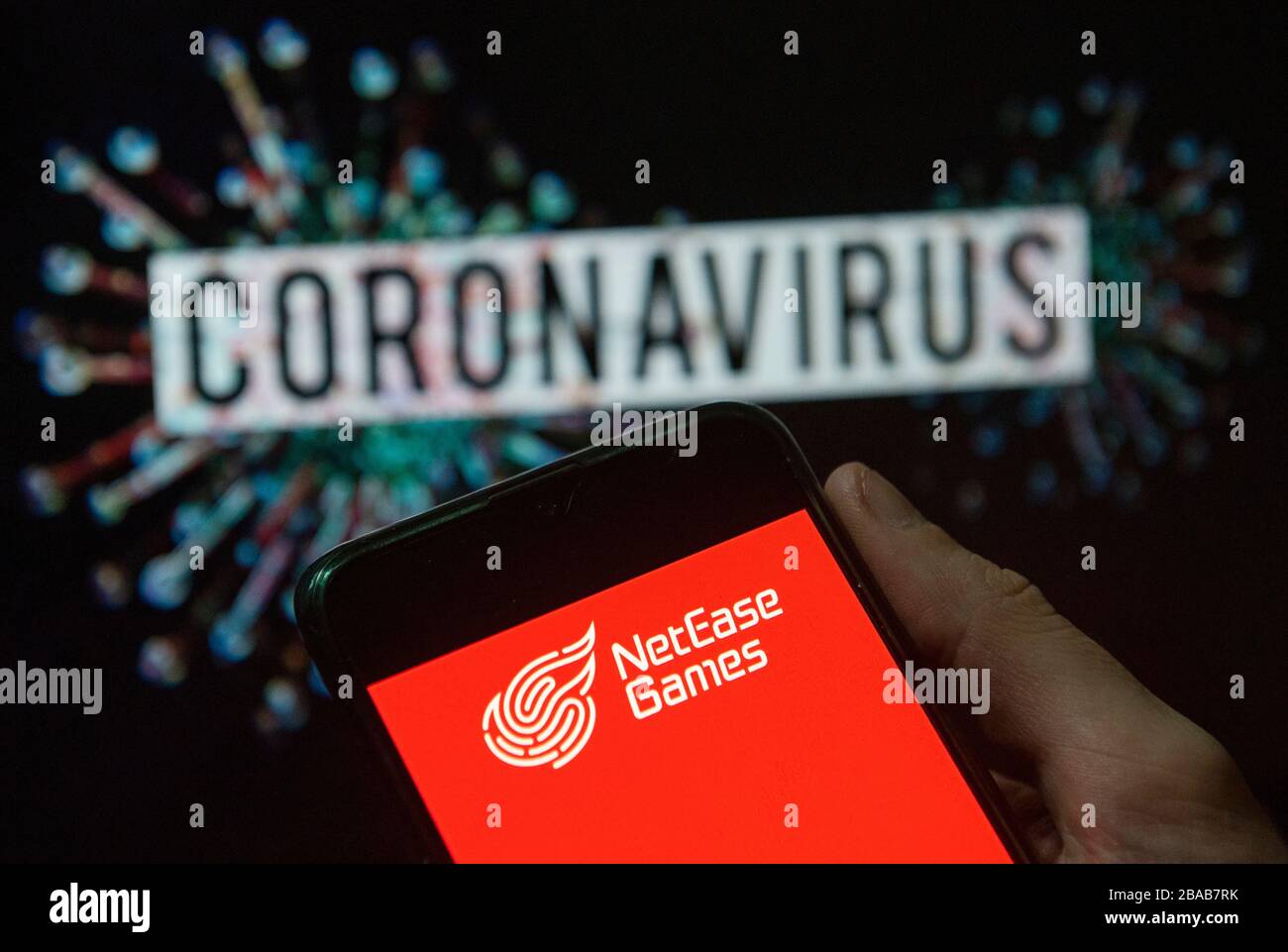 China. 24th Mar, 2020. In this photo illustration the Chinese Internet technology and online services NetEase Games logo seen displayed on a smartphone with a computer model of the COVID-19 coronavirus on the background. Credit: Budrul Chukrut/SOPA Images/ZUMA Wire/Alamy Live News Stock Photo